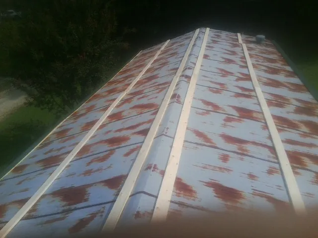 Rusted metal roof panels with new wood purlins before replacement — Storm Damage Roof Repair in Granger by Roofing Brothers